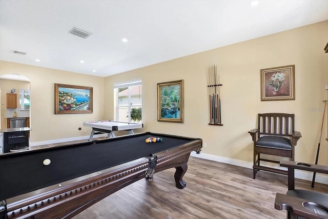 playroom with baseboards, visible vents, arched walkways, and wood finished floors