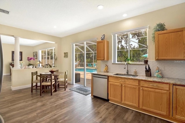 kitchen with tasteful backsplash, visible vents, stainless steel dishwasher, dark wood-type flooring, and a sink