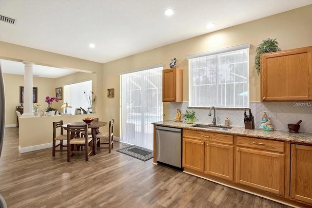 kitchen featuring a sink, visible vents, stainless steel dishwasher, light wood-type flooring, and backsplash