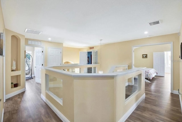 hall with baseboards, visible vents, and dark wood-style flooring