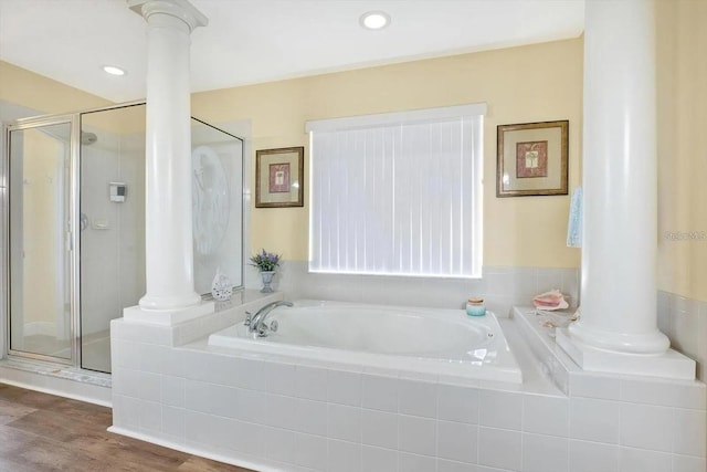 bathroom featuring ornate columns, a garden tub, and a stall shower