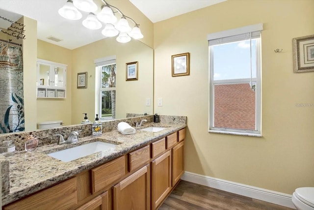 full bathroom with baseboards, a sink, toilet, and wood finished floors