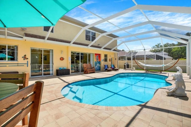 view of swimming pool featuring a patio area, fence, a fenced in pool, and a lanai