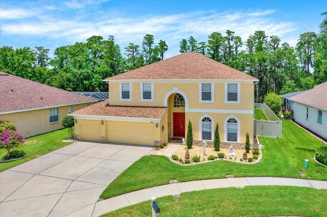 view of front of house with a garage, concrete driveway, stucco siding, fence, and a front yard