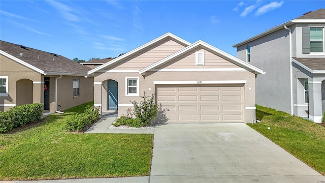 view of front of property featuring a front yard, an attached garage, driveway, and stucco siding