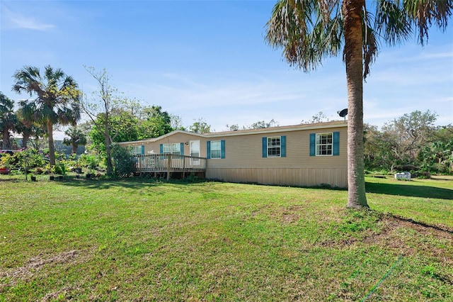 back of house with a deck and a lawn