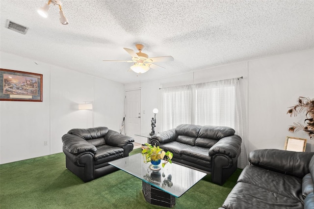 carpeted living room featuring a textured ceiling, visible vents, and a ceiling fan