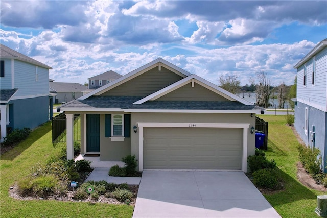 view of front facade featuring roof with shingles, stucco siding, concrete driveway, a front yard, and a garage