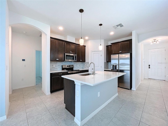 kitchen with dark brown cabinetry, visible vents, stainless steel appliances, and a sink