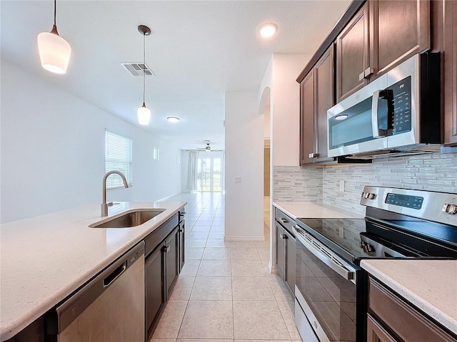 kitchen featuring stainless steel appliances, visible vents, a sink, and decorative backsplash