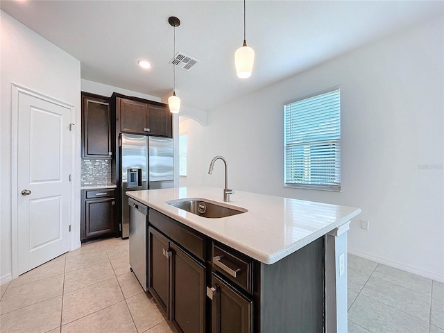 kitchen with pendant lighting, light tile patterned flooring, a sink, and stainless steel dishwasher