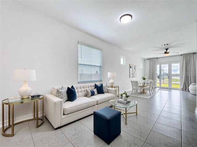 living area with baseboards, visible vents, a ceiling fan, and light tile patterned flooring