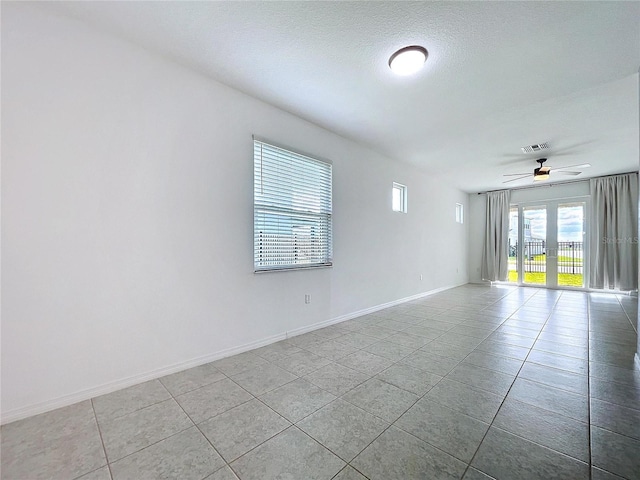 spare room with ceiling fan, a textured ceiling, visible vents, baseboards, and french doors