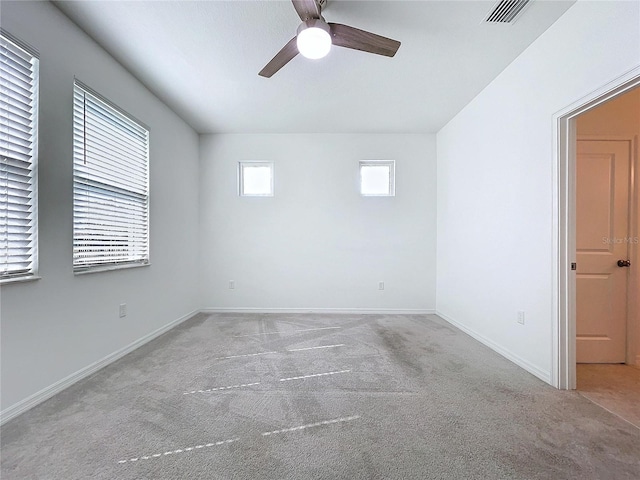 spare room featuring ceiling fan, carpet, visible vents, and baseboards