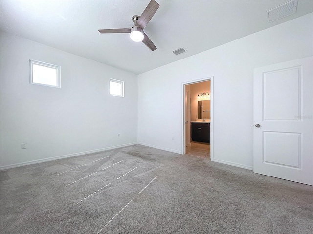 unfurnished bedroom with carpet, connected bathroom, visible vents, and baseboards