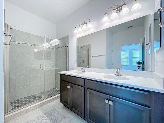 bathroom featuring visible vents, a sink, a shower stall, and double vanity