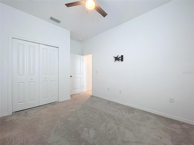 unfurnished bedroom featuring carpet floors, a closet, visible vents, ceiling fan, and baseboards