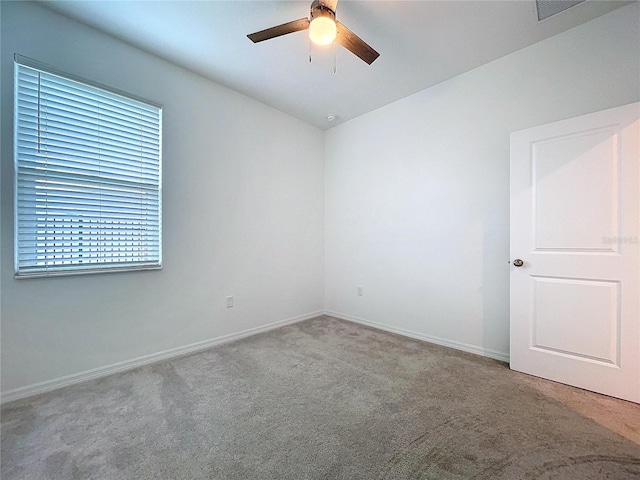 unfurnished room featuring carpet floors, ceiling fan, visible vents, and baseboards