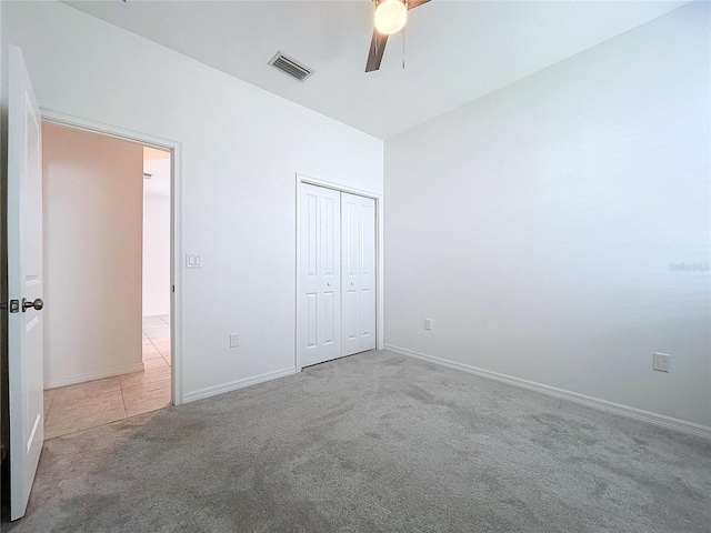 unfurnished bedroom featuring baseboards, visible vents, ceiling fan, carpet floors, and a closet