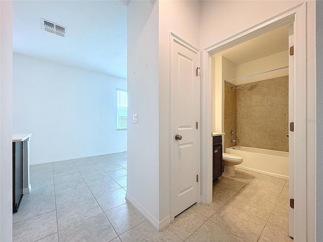 corridor with light tile patterned floors, baseboards, and visible vents