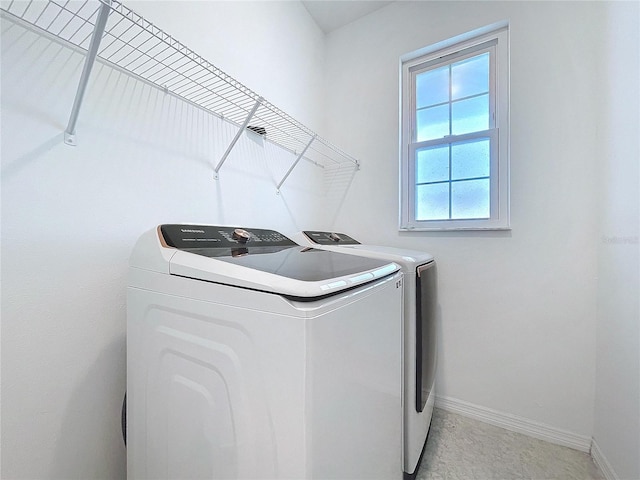 laundry area featuring laundry area, washing machine and clothes dryer, and baseboards