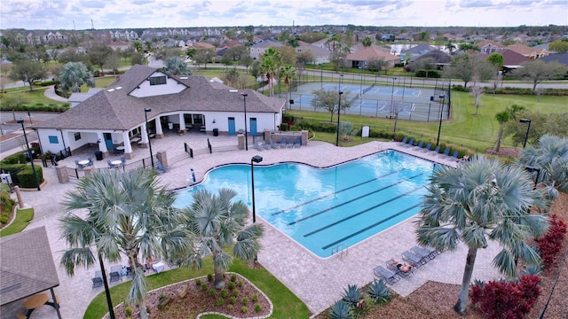 pool featuring a yard, a residential view, a patio, and fence