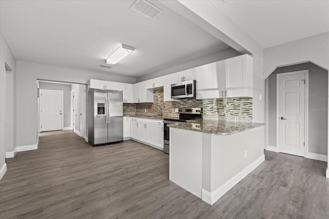 kitchen with visible vents, stone countertops, wood finished floors, stainless steel appliances, and white cabinets