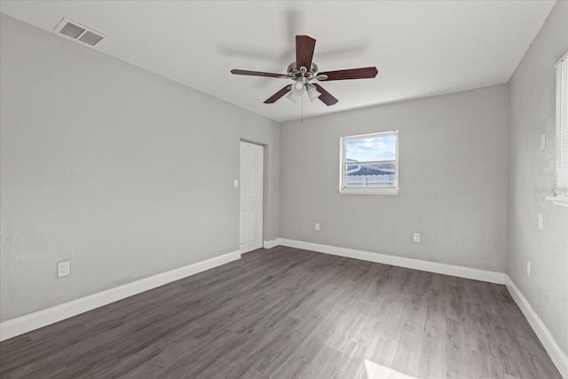 empty room featuring visible vents, baseboards, wood finished floors, and a ceiling fan