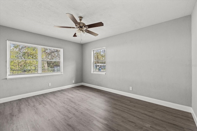 unfurnished room featuring a textured ceiling, dark wood-type flooring, baseboards, and a ceiling fan