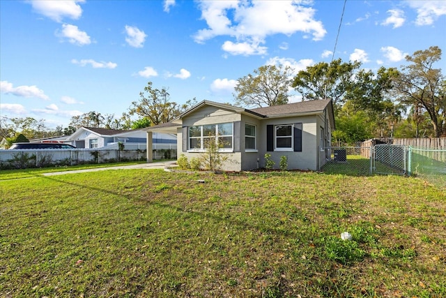 rear view of house featuring a fenced backyard, a gate, a yard, and a carport