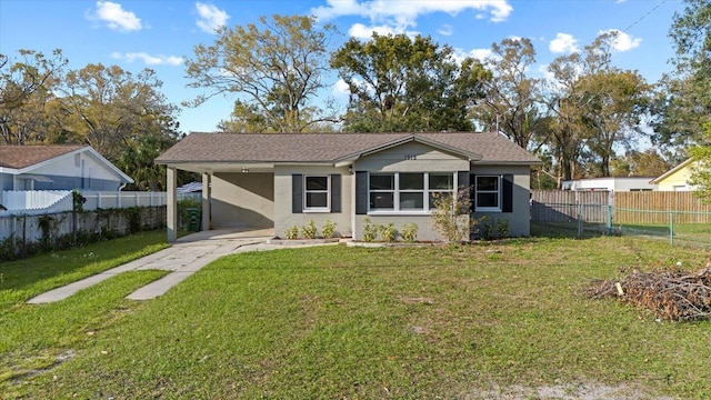 view of front of house with a front lawn, fence private yard, and driveway