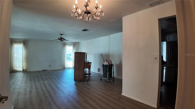 unfurnished room featuring ceiling fan with notable chandelier, a textured ceiling, wood finished floors, and visible vents