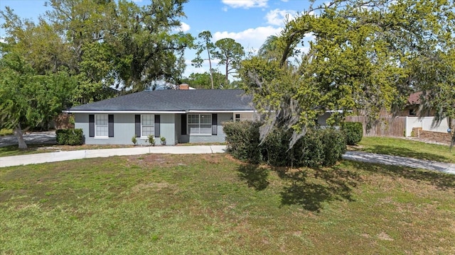 ranch-style home featuring a front lawn, fence, and a chimney