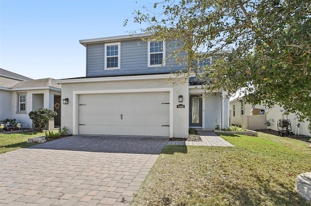 traditional home with a garage, a front yard, decorative driveway, and stucco siding