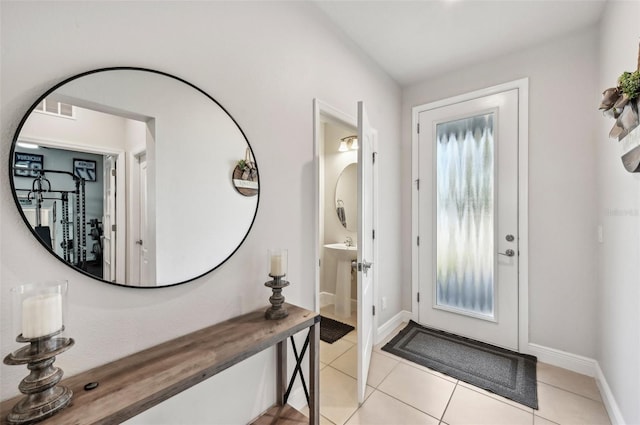 foyer entrance with light tile patterned floors, visible vents, and baseboards