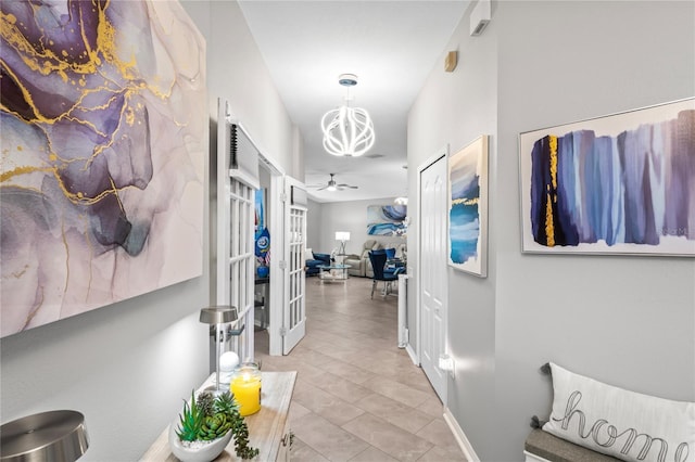 hall with tile patterned flooring and a notable chandelier