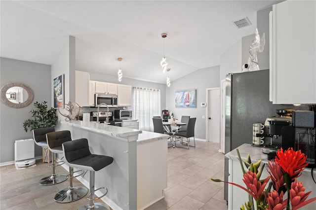 kitchen with stainless steel appliances, lofted ceiling, light countertops, white cabinets, and a peninsula