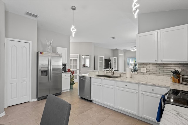 kitchen featuring a peninsula, a sink, visible vents, white cabinetry, and appliances with stainless steel finishes