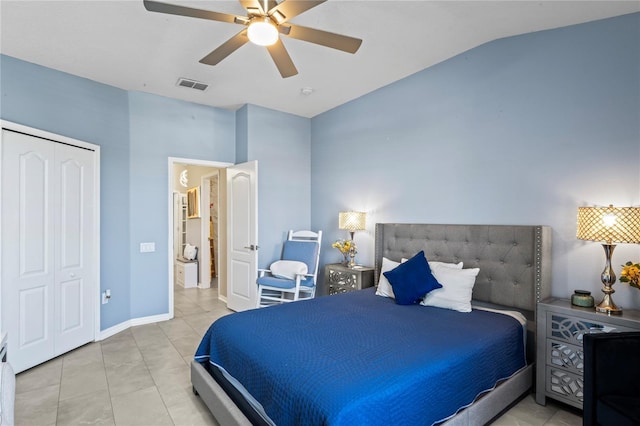 tiled bedroom with baseboards, visible vents, lofted ceiling, ceiling fan, and a closet