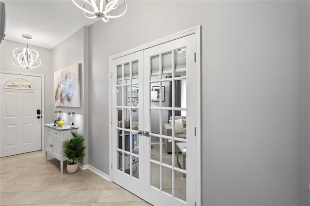 doorway to outside featuring light tile patterned floors, french doors, baseboards, and an inviting chandelier