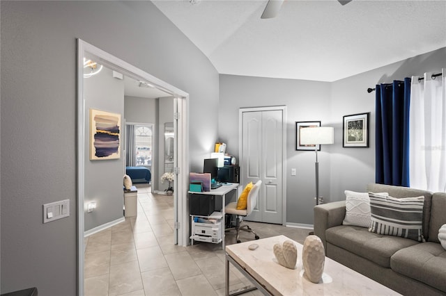 living room featuring vaulted ceiling, ceiling fan, light tile patterned flooring, and baseboards