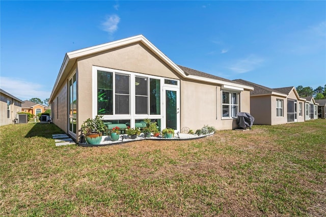 back of house with a lawn, cooling unit, and stucco siding