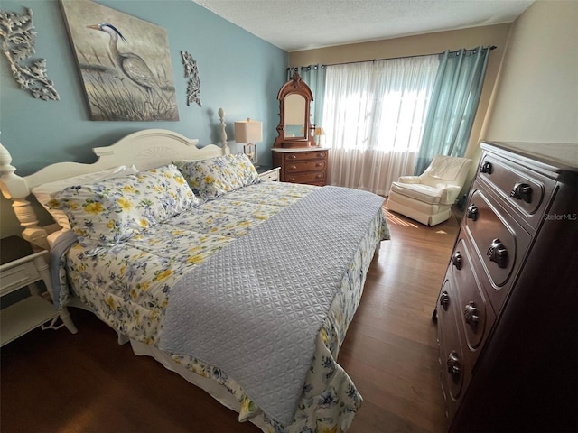 bedroom with a textured ceiling and wood finished floors