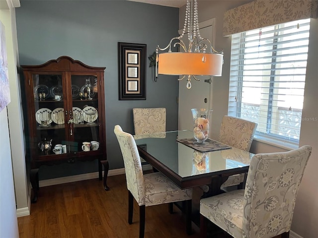 dining space with baseboards and wood finished floors
