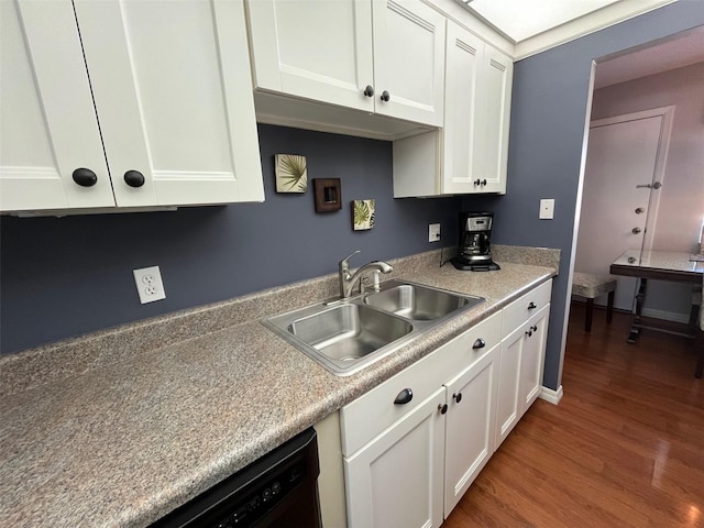 kitchen featuring white cabinetry, light countertops, a sink, and wood finished floors