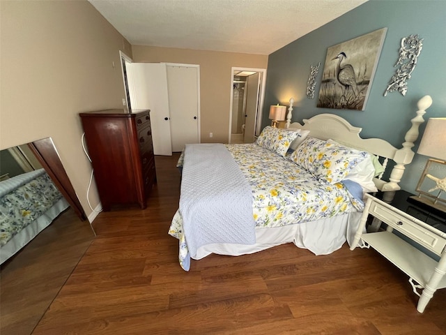 bedroom with a textured ceiling, a closet, and wood finished floors
