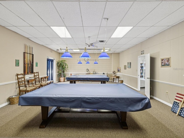 rec room featuring a paneled ceiling, carpet, and baseboards