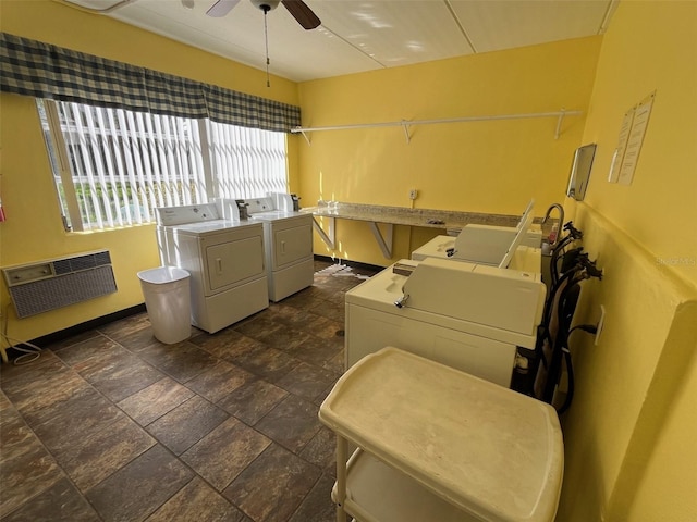 community laundry room featuring heating unit, ceiling fan, stone finish floor, and washer and dryer