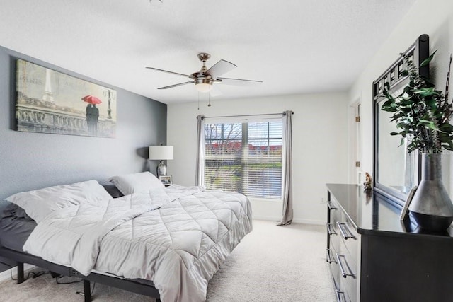 bedroom with ceiling fan, baseboards, and light colored carpet