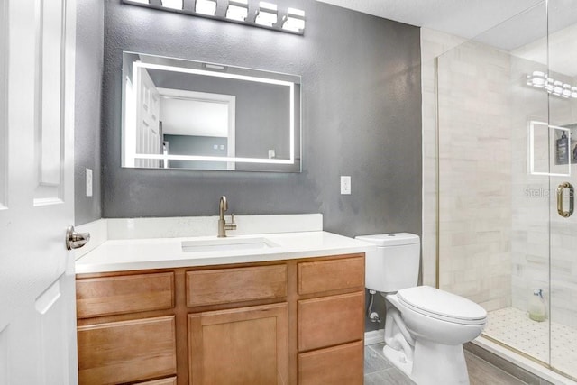 full bathroom featuring vanity, a shower stall, and toilet